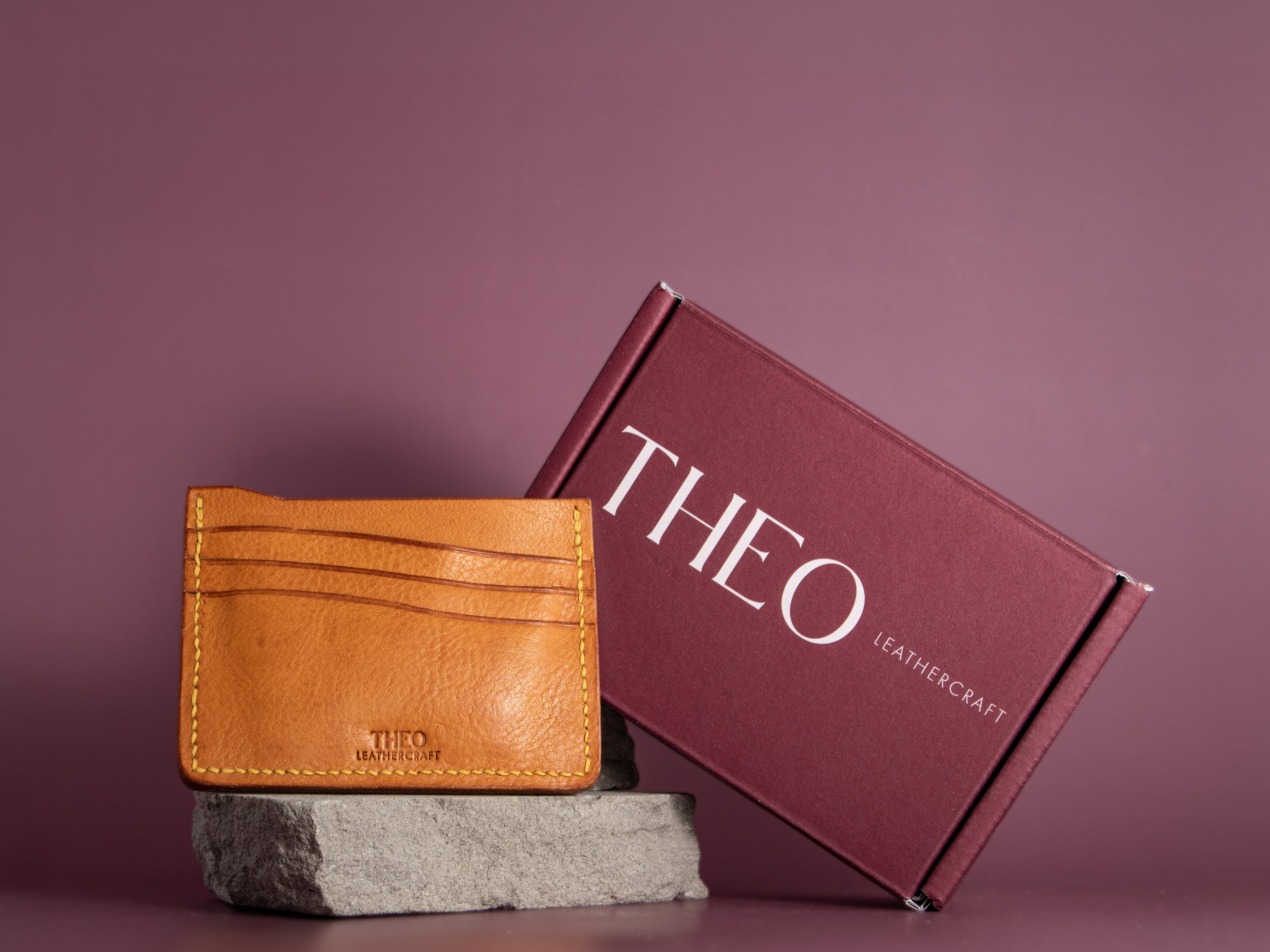 Mustard leather cardholder with 'THEO Leathercraft' branding with packaging
