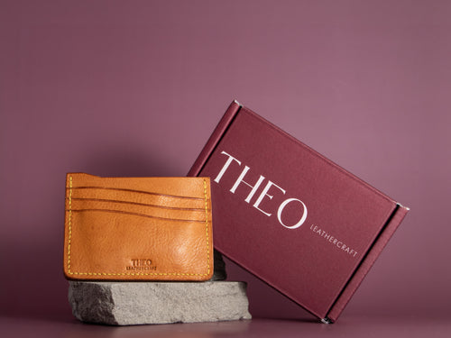 Mustard leather cardholder with 'THEO Leathercraft' branding with packaging