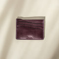 Purpler buttero leather cardholder with visible brand name on a beige background